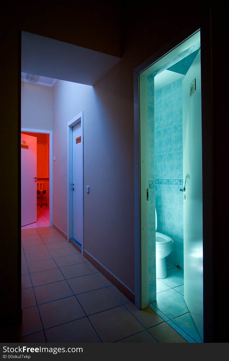 Mysterious corridor with blue light and opened doors to medical cabinet with red light and usual toilet. Mysterious corridor with blue light and opened doors to medical cabinet with red light and usual toilet.