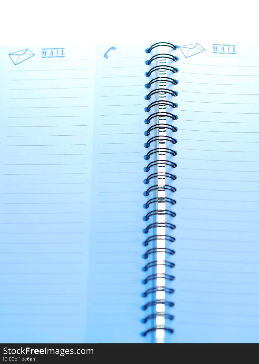 A small spiral notebook being opened ready for use