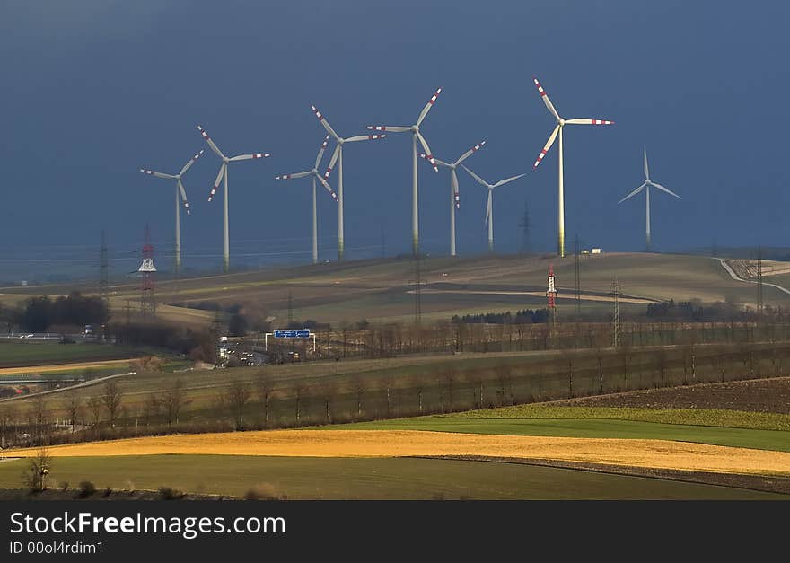 Windmills and motorway at the horizon with cloudy sky. Windmills and motorway at the horizon with cloudy sky