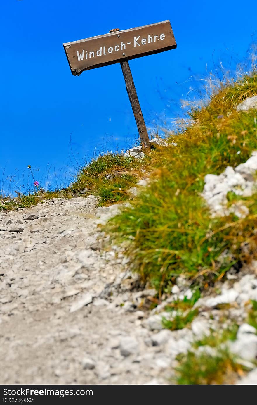 Gravel track in the mountains with way sign. Gravel track in the mountains with way sign