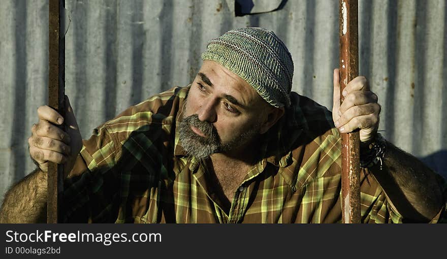 Scruffy man in a plaid shirt looking off camera. Scruffy man in a plaid shirt looking off camera.