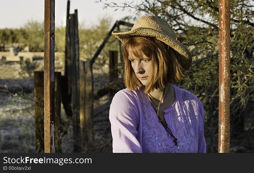 Woman wearing a cowboy hat in a rural setting. Woman wearing a cowboy hat in a rural setting.