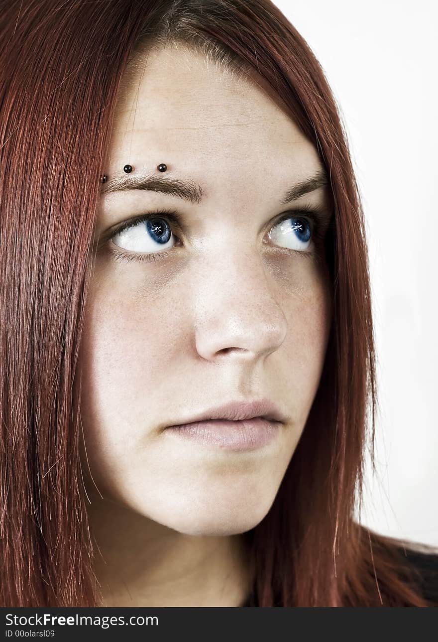 Studio shot of a cute redhead girl looking away from the camera. Studio shot of a cute redhead girl looking away from the camera.