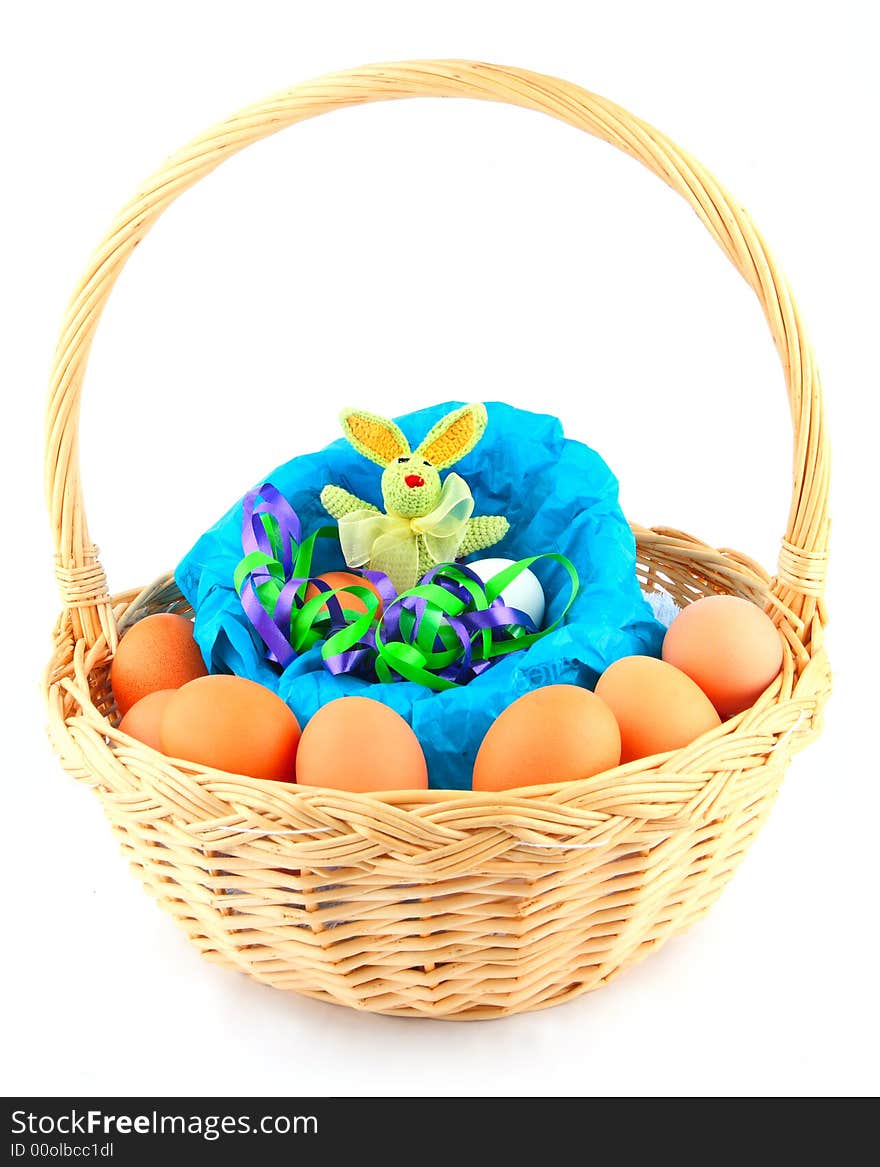 Easter bunny in a basket with multicolored chicken's eggs. Easter bunny in a basket with multicolored chicken's eggs