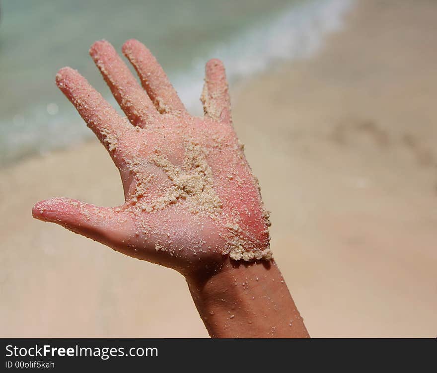 A white wet sand in sunburned hand