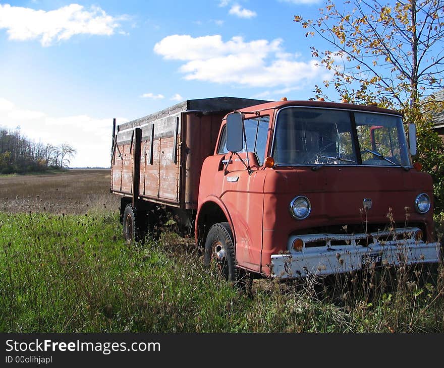 An old truck sitting in the weeds at an abandoned farm. An old truck sitting in the weeds at an abandoned farm.