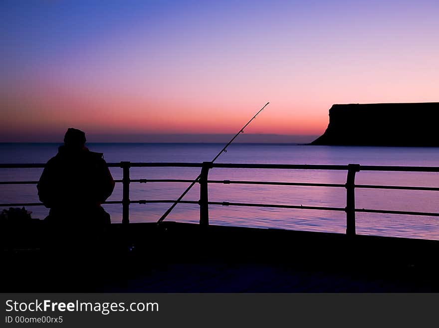 A cold still winters morn sees a lone fisherman patiently awaiting a bite. A cold still winters morn sees a lone fisherman patiently awaiting a bite