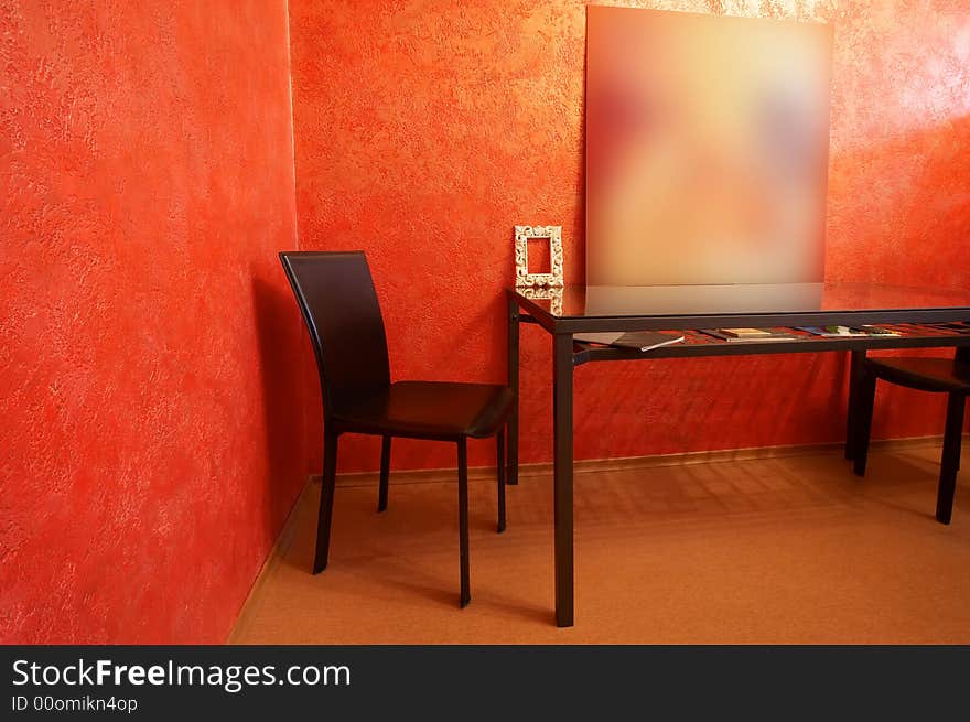 Chair and table on a background of a red wall