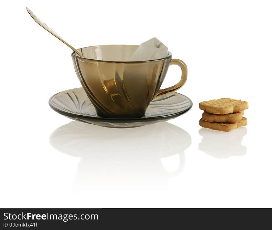 Empty glass teacup with cookie, sugar and tea bag. Empty glass teacup with cookie, sugar and tea bag.