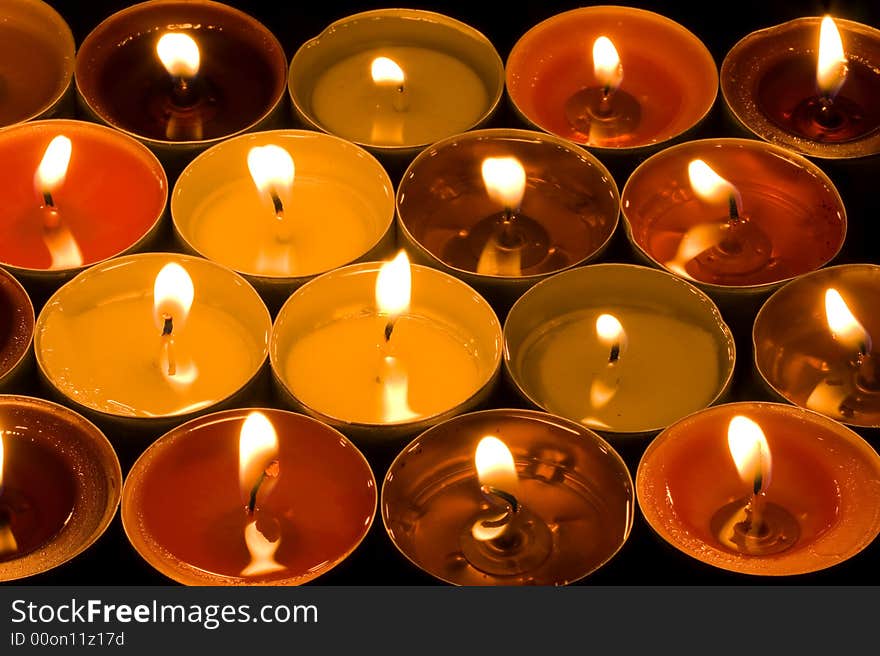 A group of burning candles on the black background