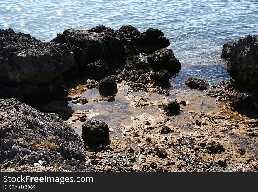 Rocks on the blue water. Rocks on the blue water