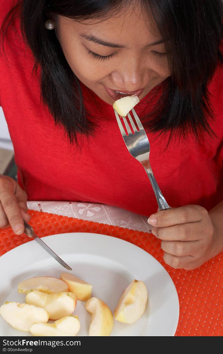 Woman eating an apple over the plate. Woman eating an apple over the plate