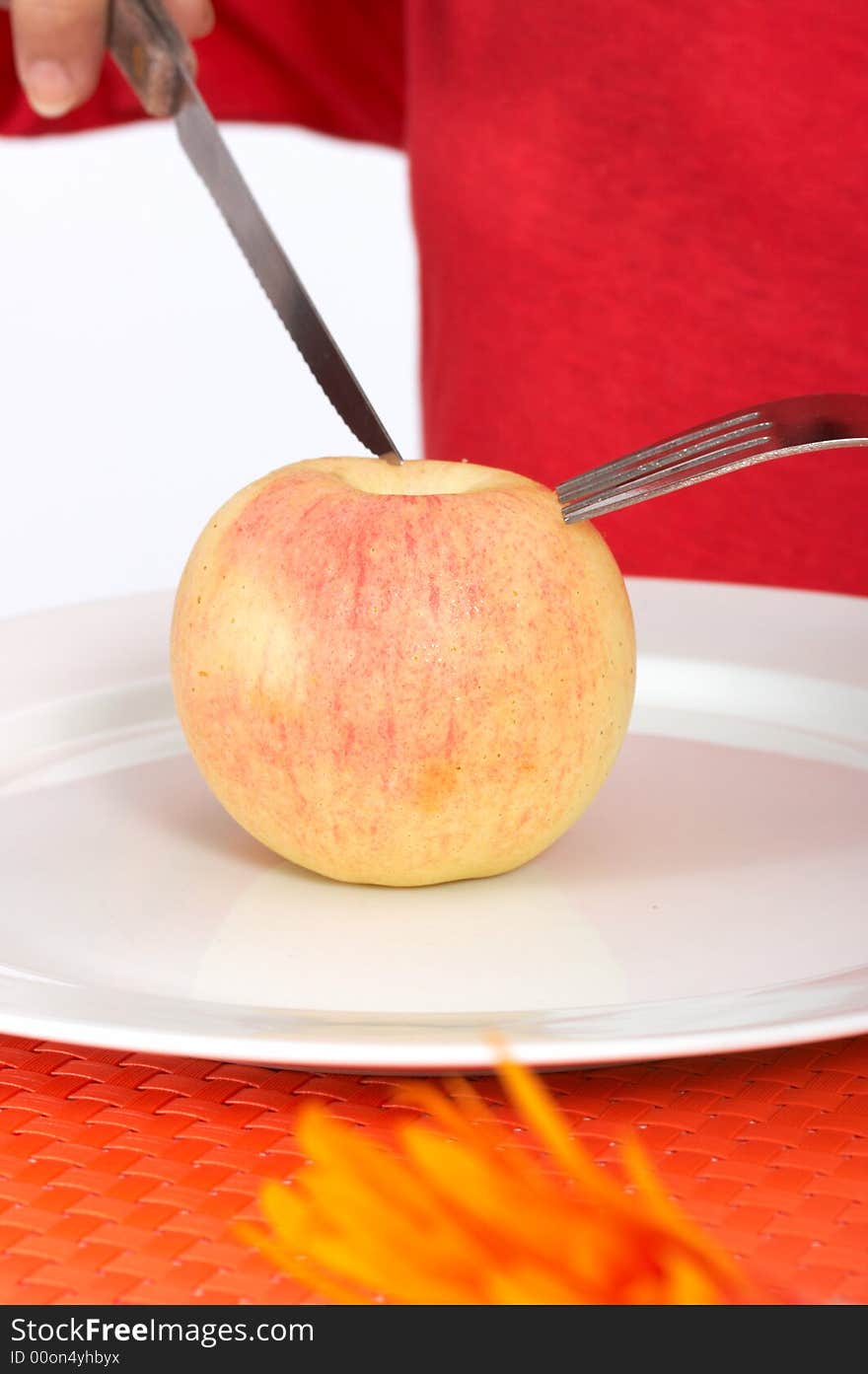 Human trying to slice an apple over a plate. Human trying to slice an apple over a plate