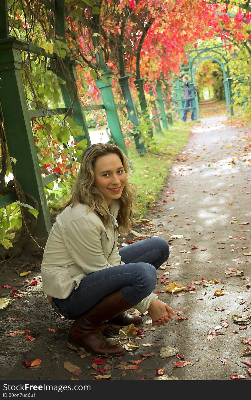 The beautiful blonde in red leaves of grapes