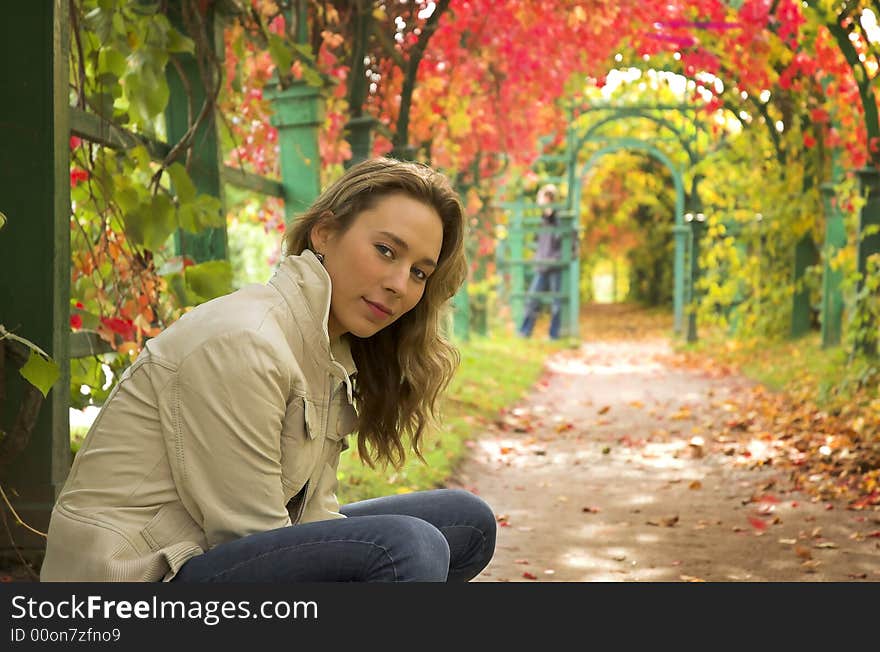 The beautiful blonde in red leaves of grapes