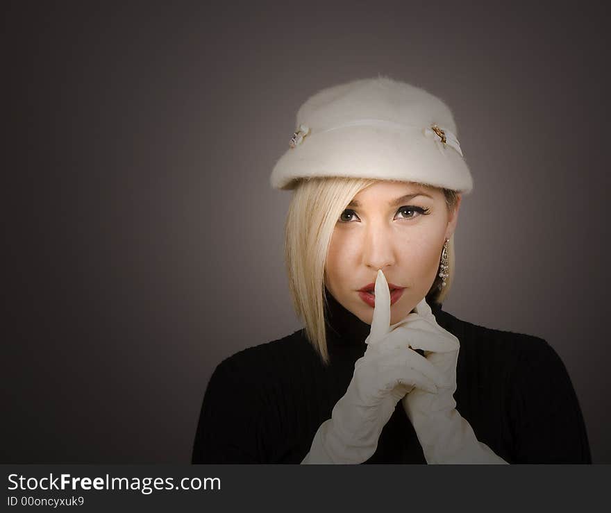 A blonde model in white hat and gloves with spotlight on face. A blonde model in white hat and gloves with spotlight on face