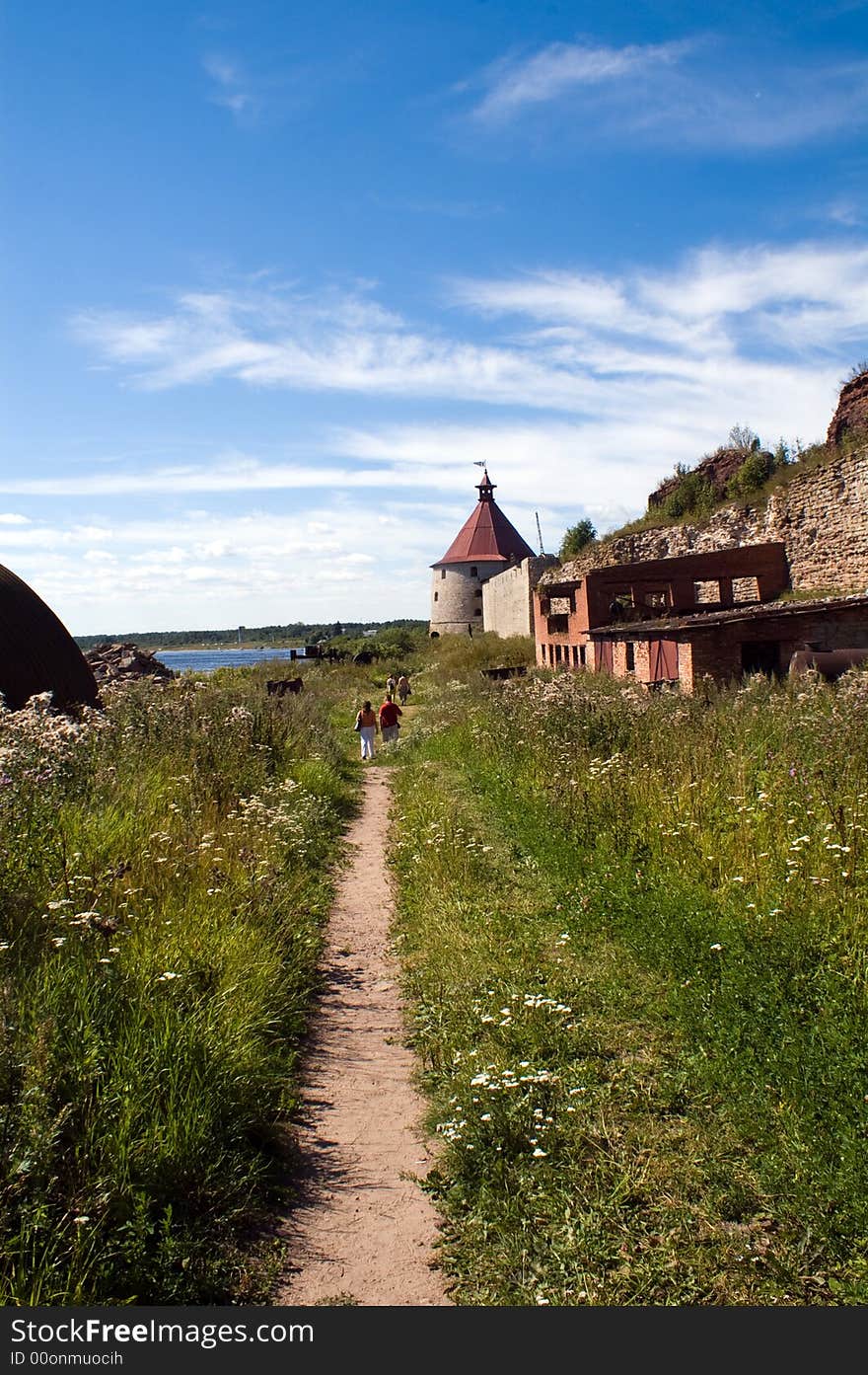 Straight pathway to acient castle at sunny summer day