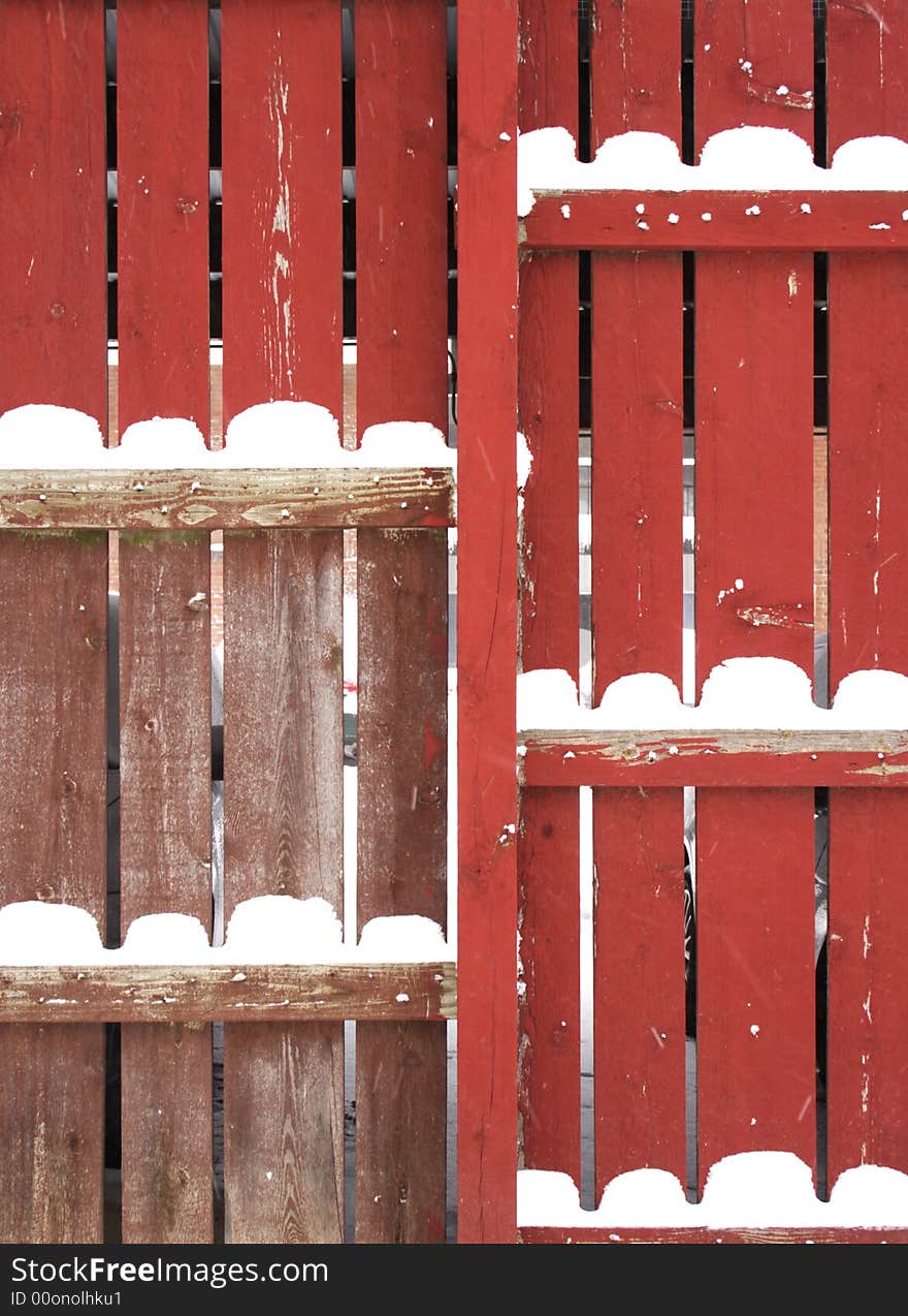 Red fence with snow piles