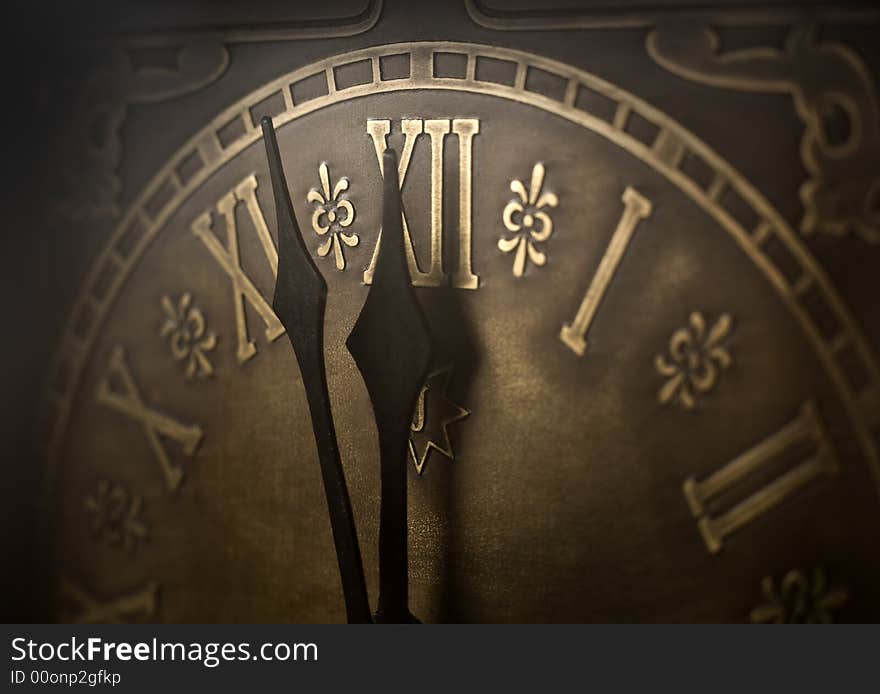 Old clock with roman numerals. Selective focus on number XII and minute hand. Intentional vignetting. Old clock with roman numerals. Selective focus on number XII and minute hand. Intentional vignetting.