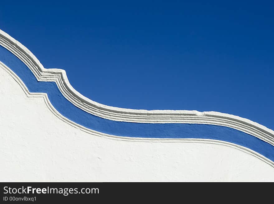 Top of a garnished curved wall adorned with a blue strip. Top of a garnished curved wall adorned with a blue strip