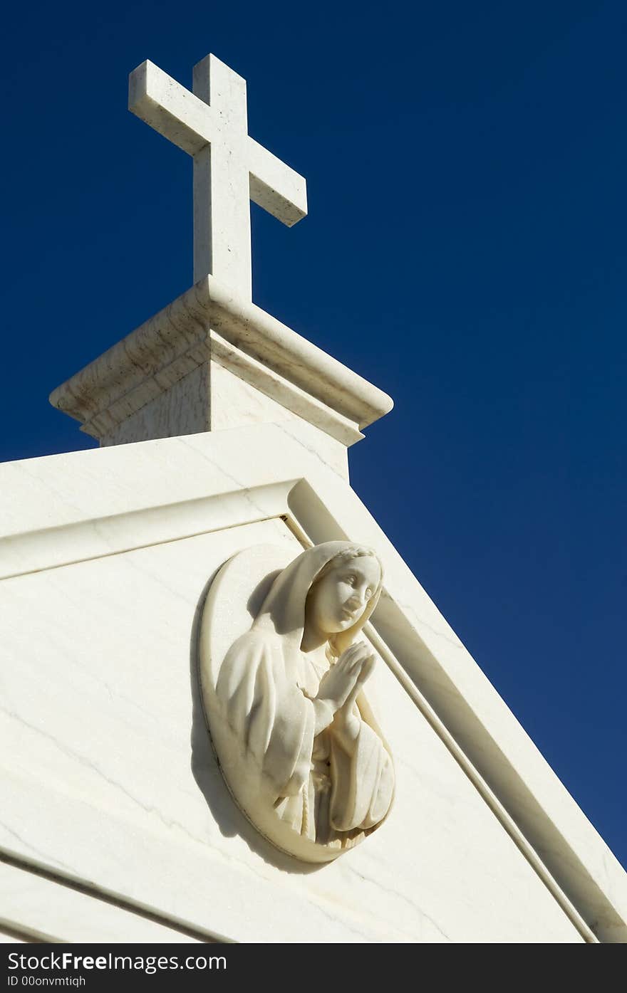 Cemetery mausoleum detail showing a saint praying