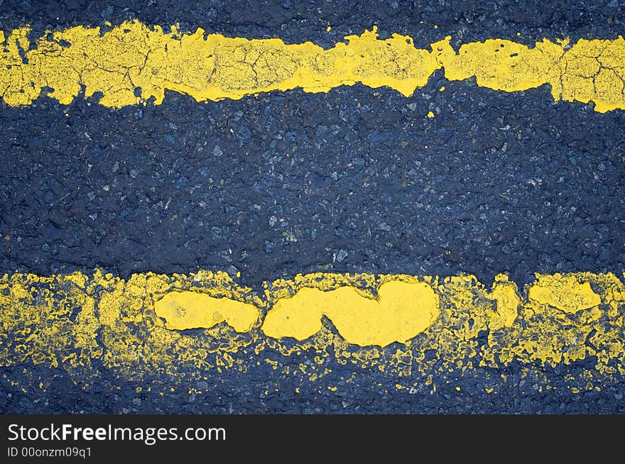 Worn road markings (double yellow lines) with an interesting texture.