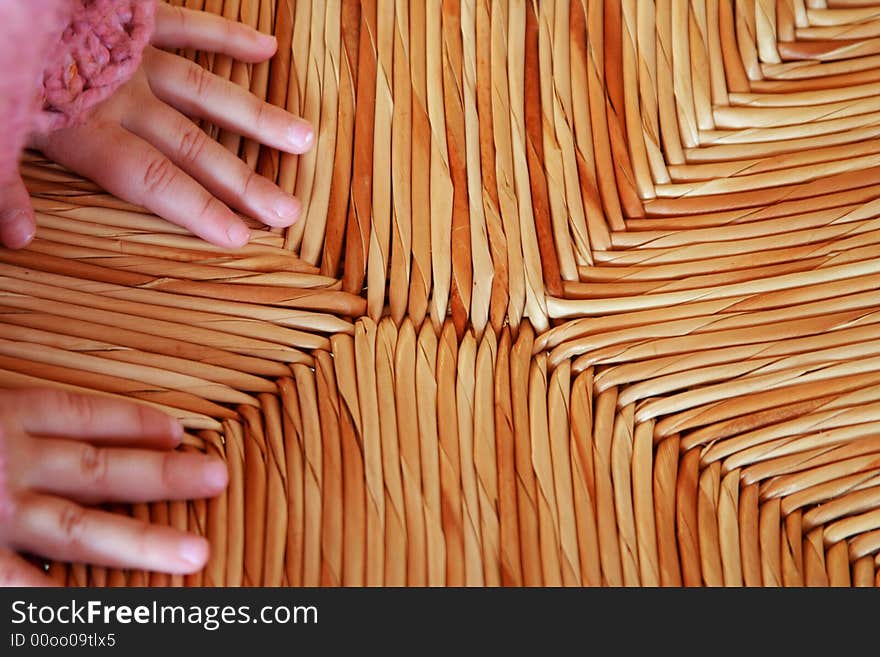 Child hands on a warm straw chair. Child hands on a warm straw chair