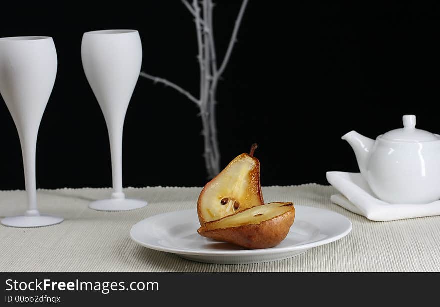 A gormet roasted pear with a modern table setting. A gormet roasted pear with a modern table setting