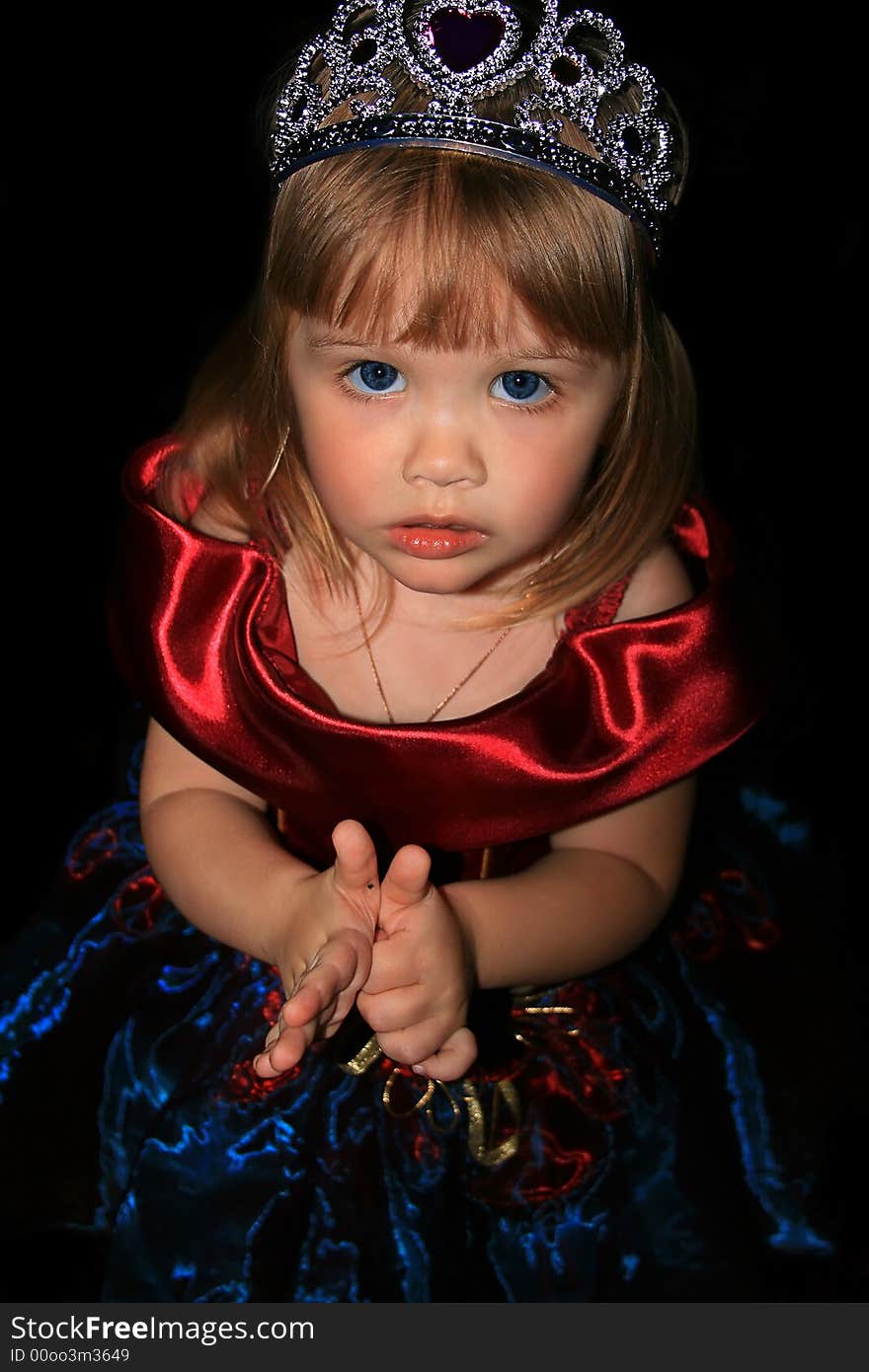 The girl in a beautiful velvet dress. A black background. The girl in a beautiful velvet dress. A black background