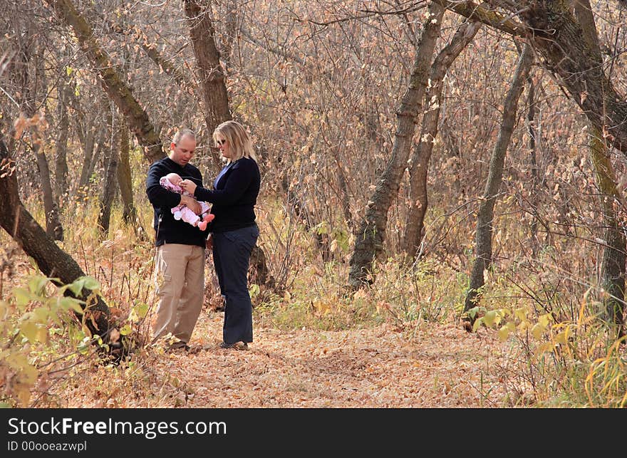 A young family enjoying a quiet moment while walking in the Autumn woods. A young family enjoying a quiet moment while walking in the Autumn woods.