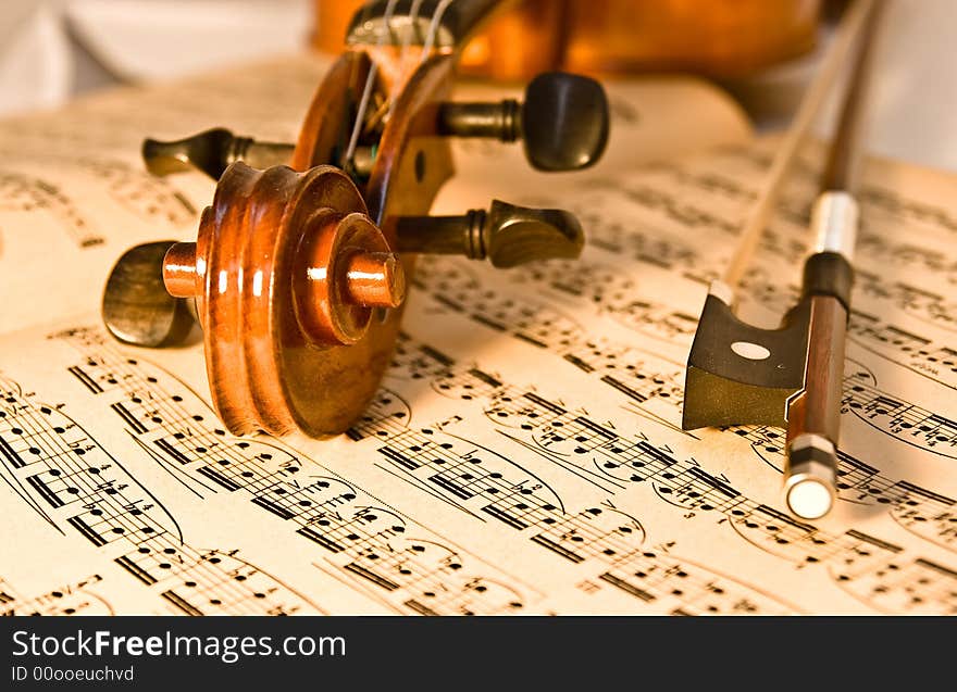 A violin and bow resting on a piece of aged classical music.