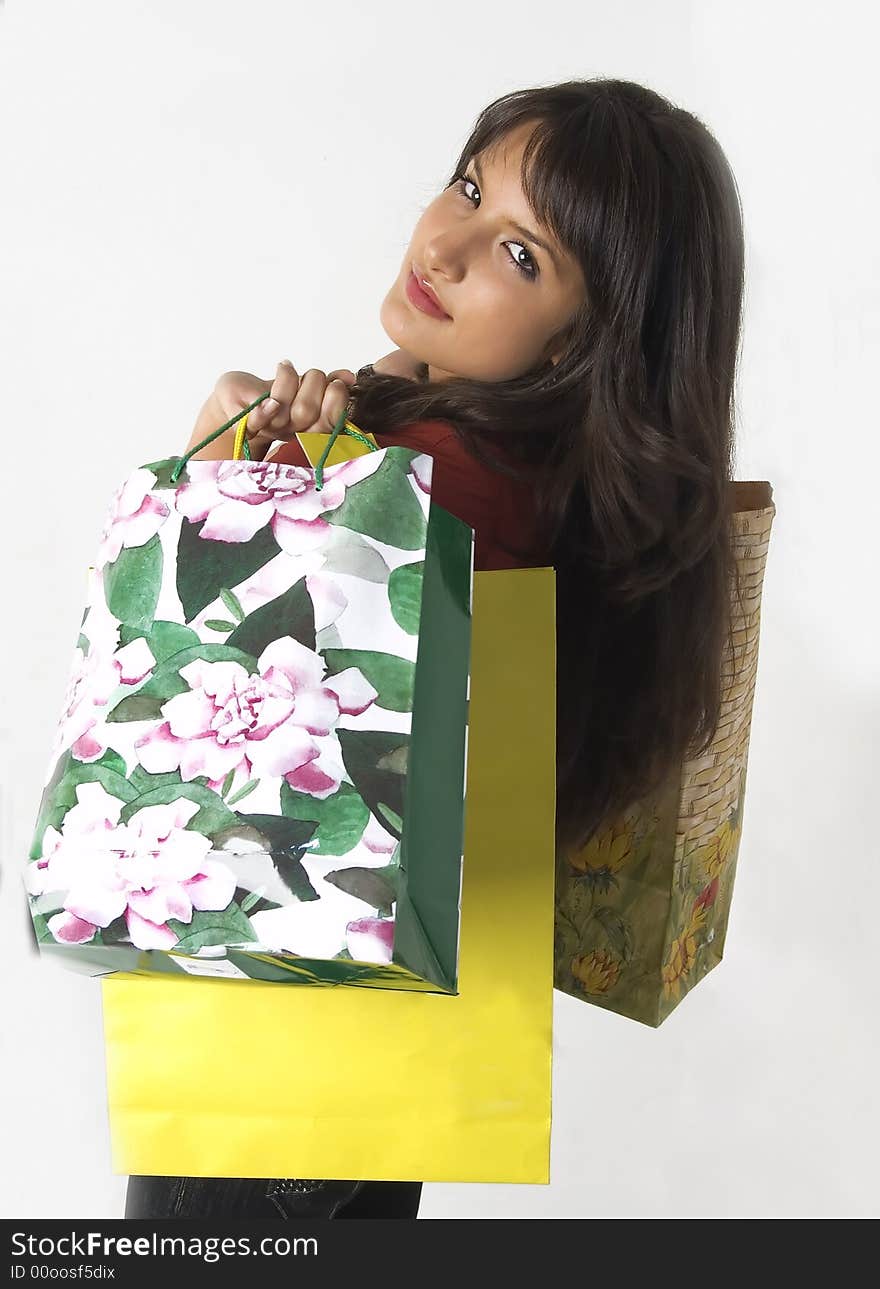 Pretty young woman with green yellow and beige shopping bags. Pretty young woman with green yellow and beige shopping bags