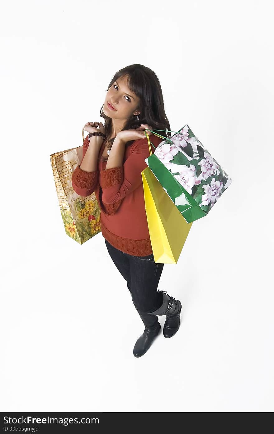 Pretty young woman with green, yellow and beige shopping bags. Pretty young woman with green, yellow and beige shopping bags