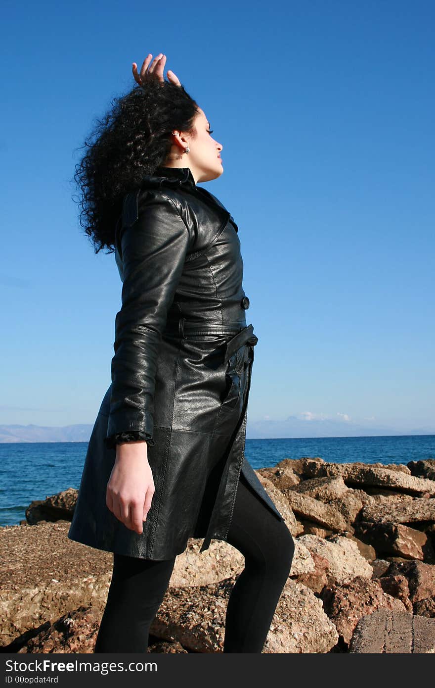 A young woman in leather jacket under the blue sky