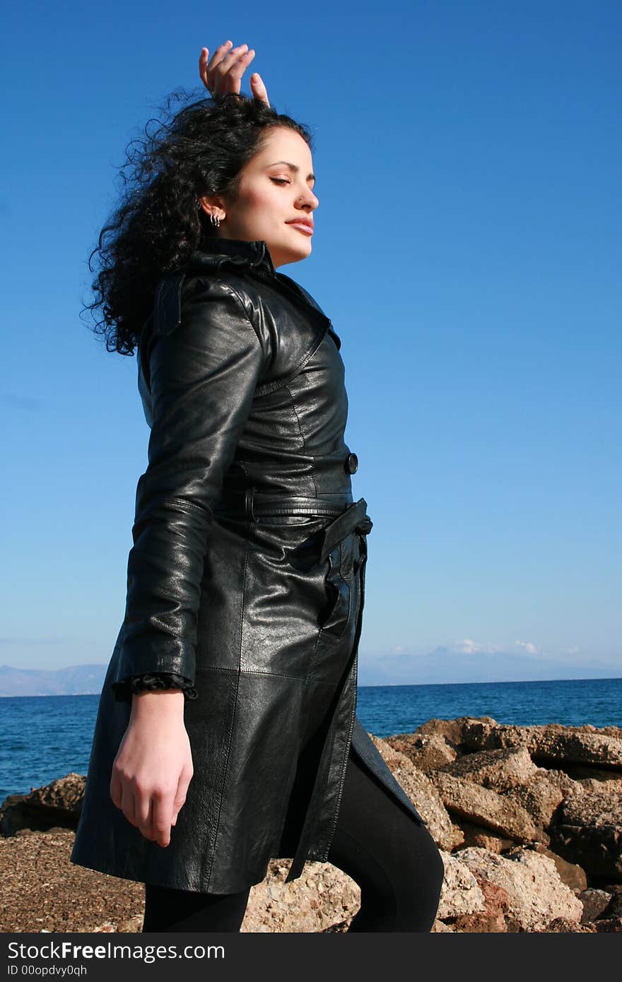 A young woman in leather jacket under the blue sky