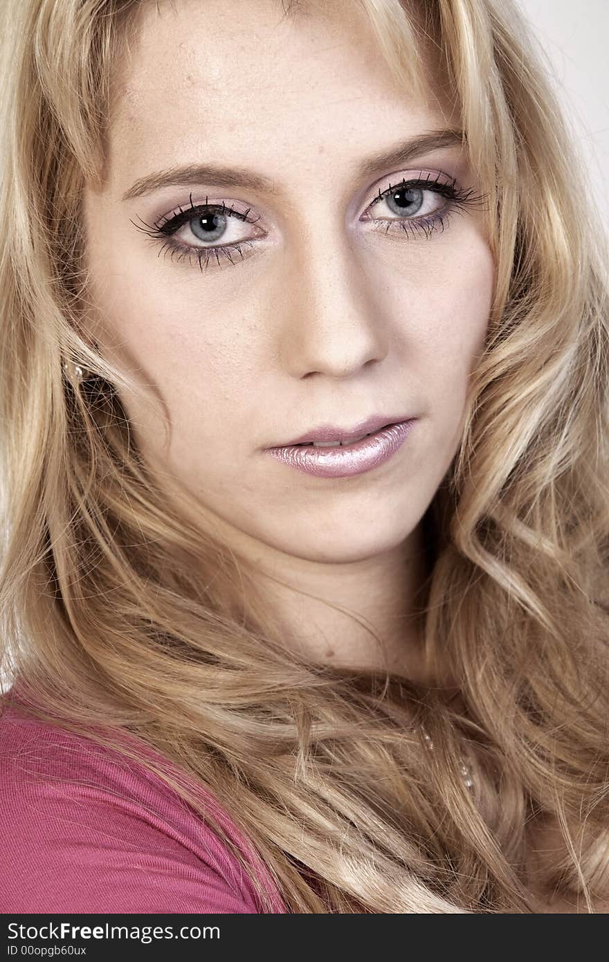 Studio portrait of a long blond girl looking hurt