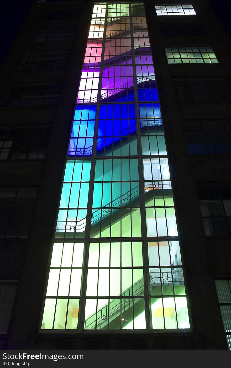 Modern multicolour building at night, each floor has been lit with a different colour bulbs. Modern multicolour building at night, each floor has been lit with a different colour bulbs