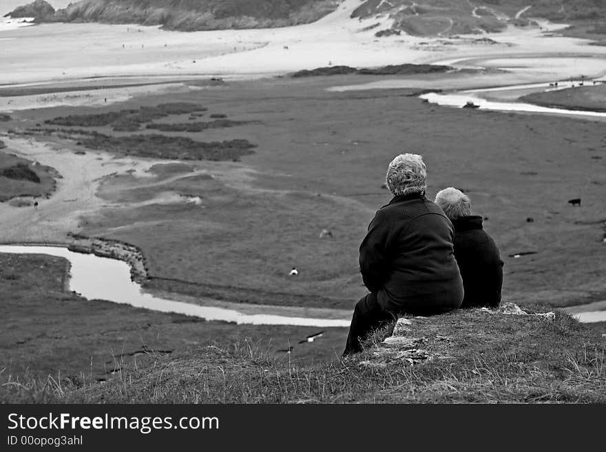 Senior couple taking in the view of Pennard valley in the gower peninsula. Senior couple taking in the view of Pennard valley in the gower peninsula