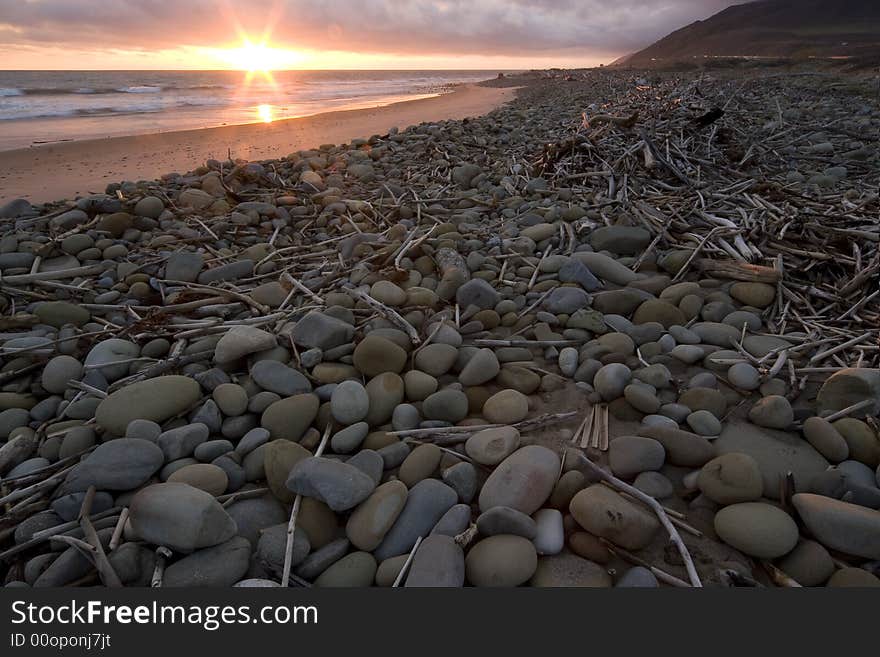 Driftwood and stones left on beach after a storm at sunset in Ventura, Ca. Driftwood and stones left on beach after a storm at sunset in Ventura, Ca.