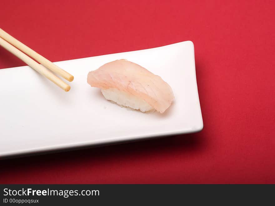Sushi crude fish on a white plate over a reddish background