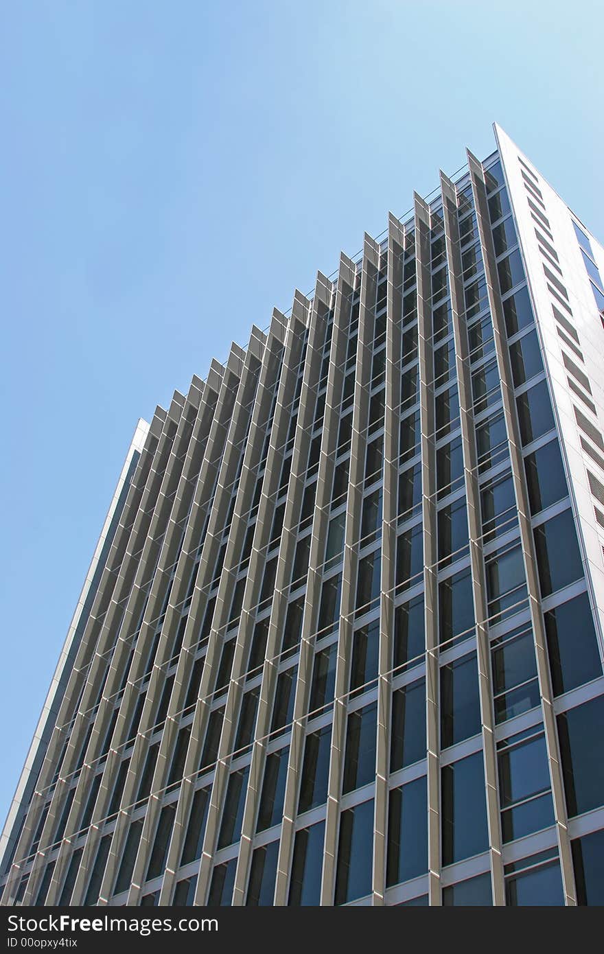 Tall black office building against a bright blue sky. Tall black office building against a bright blue sky