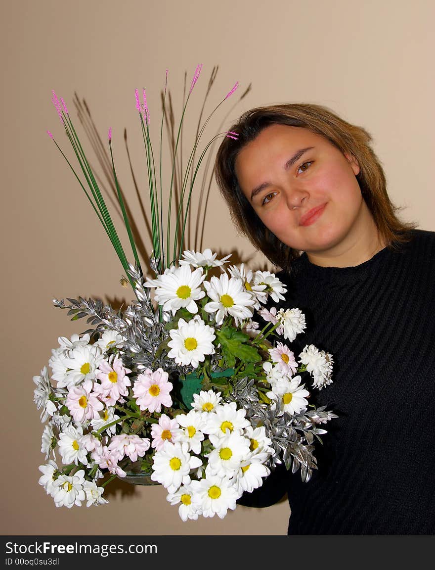 The lovely girl poses with a bouquet of flowers. The lovely girl poses with a bouquet of flowers