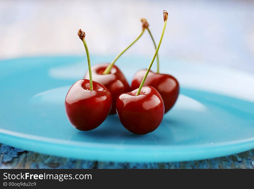 Four cherries on a plate