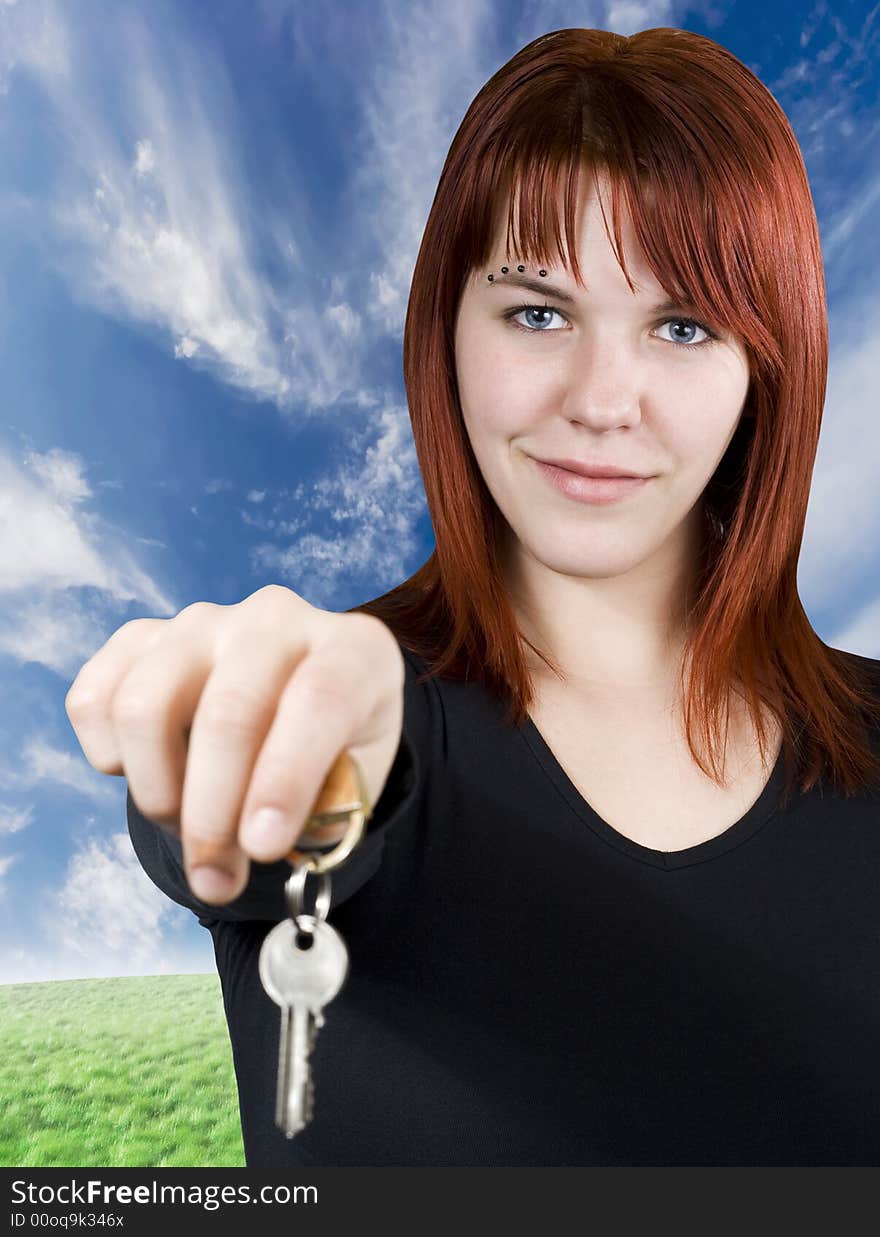 Cute smiling redhead girl holding keys towards the camera. Cute smiling redhead girl holding keys towards the camera.