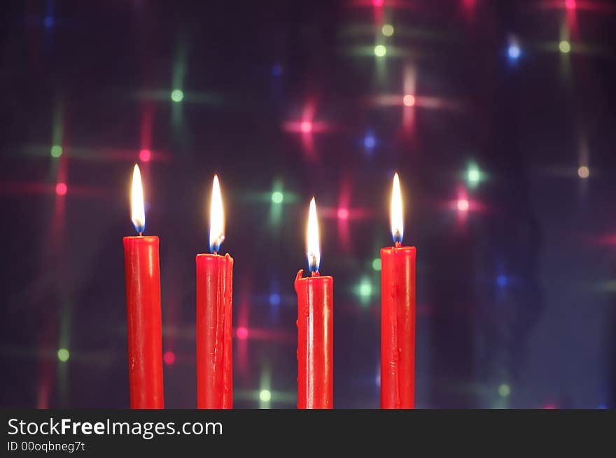 Four Christmas  red candles against glow backdrop. Four Christmas  red candles against glow backdrop