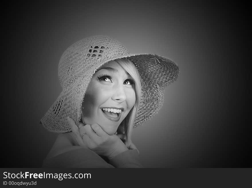 A blonde model with a straw hat smiling in black and white. A blonde model with a straw hat smiling in black and white