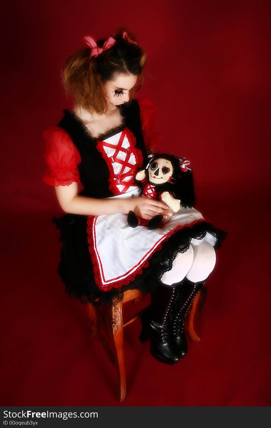 Beautiful young hispanic woman dressed as doll holding matching ragdoll. Beautiful young hispanic woman dressed as doll holding matching ragdoll.