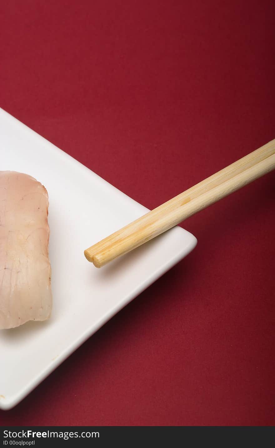 Sushi crude fish on a white plate over a reddish background