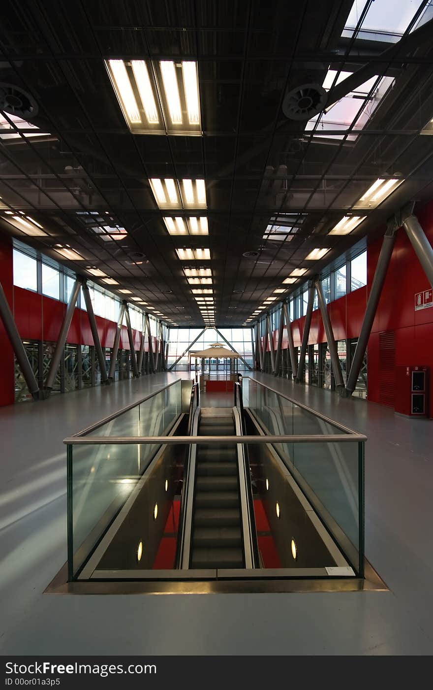 Interior of an industrial modern building with an escalator at the centre