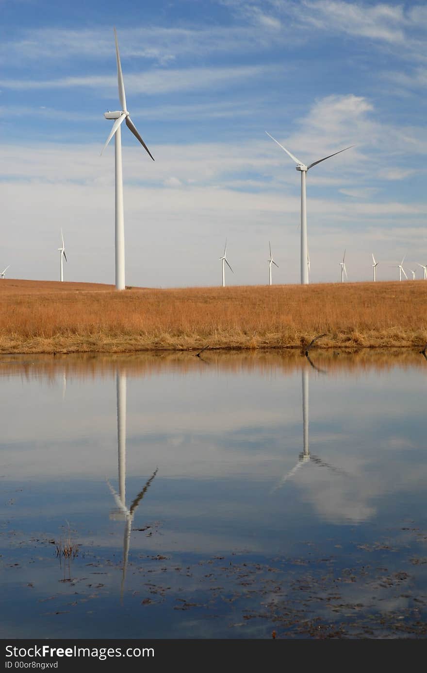 Turbines from an ecologically friendly wind farm reflected in a small pond. Turbines from an ecologically friendly wind farm reflected in a small pond.